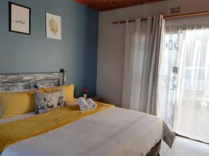 um quarto com uma cama grande e uma janela em Tokelo Guesthouse Emalahleni em Witbank