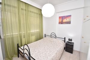 a bedroom with a bed and a green curtain at Central Apartment Thessaloniki-Easy Parking in Thessaloniki