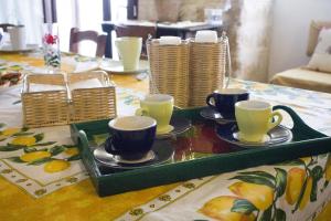 a green tray with cups and saucers on a table at Masseria Marico in Castellaneta