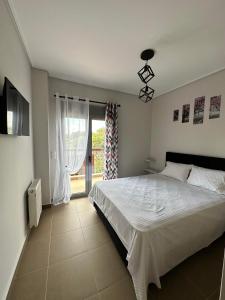 a bedroom with a large white bed and a window at EVa's Luxury Apartments No 3 in Áyios Spirídhon