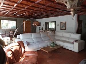 uma sala de estar com um sofá branco e uma mesa em Lalmendra. 