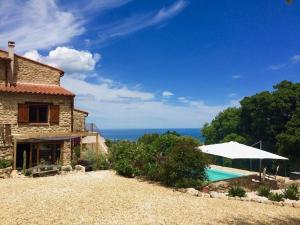 a house with a swimming pool and an umbrella at Wanakaset Pyrénées Orientales in Argelès-sur-Mer