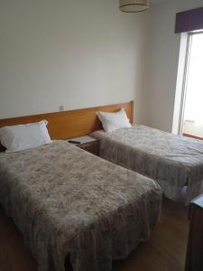um quarto de hotel com duas camas e uma janela em Arcádia by Umbral em Fátima