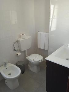 a white bathroom with a toilet and a sink at Arcádia by Umbral in Fátima