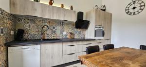 a kitchen with wooden cabinets and a table with chairs at Bel & ancien appartement T3 rénové dans Sartène in Sartène