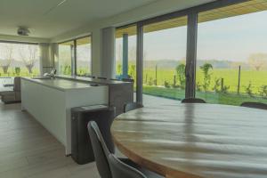 a large kitchen with a table and a large window at Villa Steedje in Jabbeke