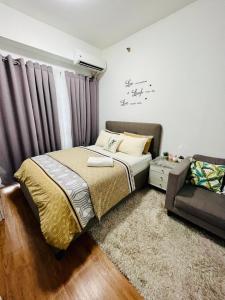 1 dormitorio con 1 cama y 1 sofá en Lovely studio unit with fast Wi-Fi and Netflix, en Tagaytay