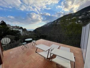 a patio with a table and chairs on a balcony at Villa Maera Ravello in Ravello