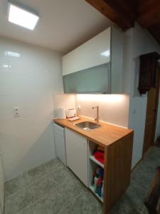 una pequeña cocina con fregadero y encimera en Casa Rústica da Lavandeira, en Valongo dos Azeites