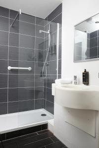 a white bathroom with a shower and a sink at Mercure Darlington King's Hotel in Darlington