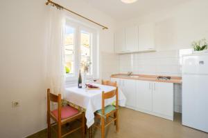 a kitchen with a table and chairs and a window at Kob Orog good location with sea views and modern decor in Metajna +33 photos