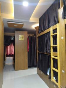 a dressing room with black shirts and racks of clothes at Super Champions Hostel in Mumbai