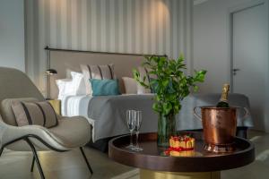SOLYMAR Gran Hotel في كاليبي: غرفة نوم مع سرير وطاولة مع زجاجة من الشمبانيا