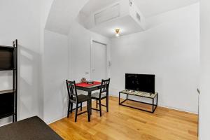 een woonkamer met een tafel en stoelen en een televisie bij Alessia's Flat - San Luigi in Milaan