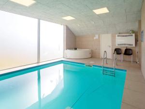 - une piscine d'eau bleue dans une chambre dans l'établissement Holiday home Snedsted V, à Snedsted