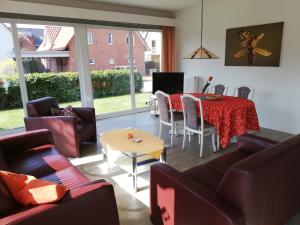 a living room with a table and chairs at Ferienwohnungen Meeres-Brise - Weißer Weg in Bad Zwischenahn