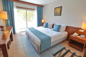 Un dormitorio con una cama grande y una ventana en Happy Hotel Kalkan, en Kalkan