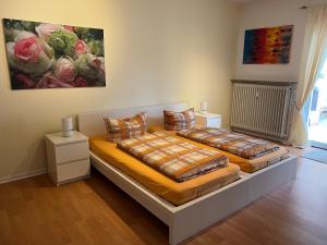 two beds in a room with a painting on the wall at Ferienwohnungen Meeres-Brise - Weißer Weg in Bad Zwischenahn