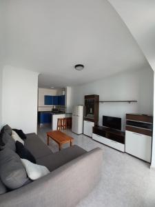 sala de estar con sofá y cocina en Apartamentos Las Canteras Arena, en Las Palmas de Gran Canaria