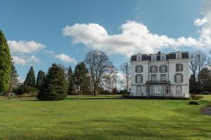 a large white house on a grassy field at Château Charles in Pepinster