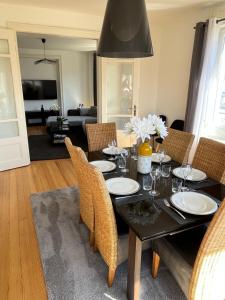 uma sala de jantar com uma mesa preta e cadeiras em Appartement de Prestige au centre avec jardin privé em Colmar