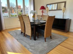 a dining room table with wicker chairs and a table and chairsktop at Appartement de Prestige au centre avec jardin privé in Colmar