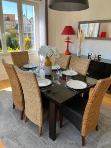 uma sala de jantar com uma mesa preta e cadeiras em Appartement de Prestige au centre avec jardin privé em Colmar