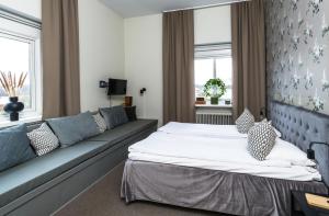 a hotel room with a bed and a couch at Stora Hotellet Markaryd in Markaryd
