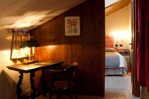 a bedroom with a desk and a bed and a table at Hotel Ristorante Il Principe in Claviere