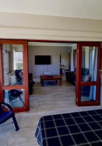 a living room with a couch and a tv at Zoete Inval - 3 Bedroom Self Catering Home. in Langebaan