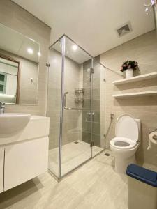 une salle de bains avec douche, toilettes et lavabo dans l'établissement Vinhomes Smartcity-Căn hộ dich vụ-Zhomestay, à Phú Thú