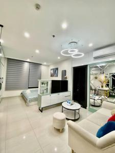 un salon avec un canapé et une télévision dans l'établissement Vinhomes Smartcity-Căn hộ dich vụ-Zhomestay, à Phú Thú