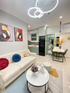 un salon avec un canapé blanc et une table dans l'établissement Vinhomes Smartcity-Căn hộ dich vụ-Zhomestay, à Phú Thú