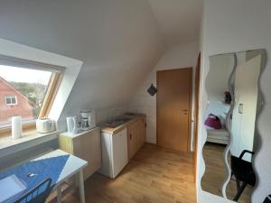 a small kitchen with a sink and a table at Ferienwohnungen Meeres-Brise - Weißer Weg in Bad Zwischenahn