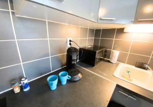 um balcão de cozinha com comodidades para preparar café e um lavatório em Au 45' - Poitiers - Futuroscope - La Conciergerie em Poitiers