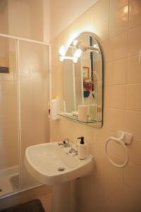 a bathroom with a sink and a mirror and a shower at Primor Serra AL 2 in Covilhã