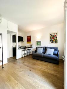 een woonkamer met een bank en een keuken bij tHE Mundial Studio - Bosco Verticale View in Milaan