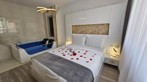 ein Schlafzimmer mit einem Bett mit roten Rosen darauf in der Unterkunft Colț de Rai Reşița ( Centru ) in Reşiţa