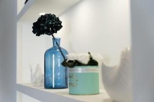 a blue vase with a plant in it on a shelf at Hotel The Sea in Rimini