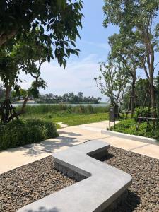 a stone bench in the middle of a walkway at Cassia Residence Laguna Phuket Holiday Rental Apartment, Bang Tao Beach in Phuket Town