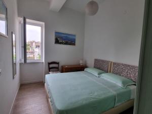 1 dormitorio con cama y ventana en Bella D'Estate - 10 minutes from the beach, en Isquia