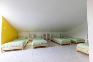 um quarto com 3 camas num sótão em Pineapple Surf House em Peniche