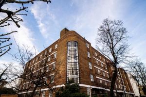 een hoog bakstenen gebouw met de hemel op de achtergrond bij Bowden Court (Notting Hill) in Londen