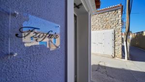 a blue building with a white garage door with graffiti at Tzofa's Apartment in Ermioni