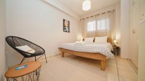 Tzofa's Apartment في إرميوني: غرفة نوم فيها سرير وكرسي