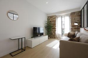 uma sala de estar com um sofá e uma televisão de ecrã plano em Apartment in Donostia well connected downtown em Pasajes Ancho