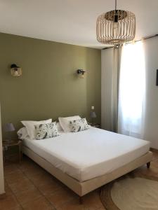 a bedroom with a large white bed with a window at Chez Dume in Santa-Lucia-di-Tallano