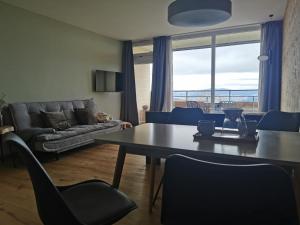 a living room with a table and chairs and a couch at Sternstube – Appartement mit traumhaftem Weitblick in Freyung