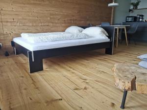 een bed in een kamer met een houten vloer bij Sternstube – Appartement mit traumhaftem Weitblick in Freyung