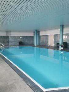 een groot zwembad met blauw water in een gebouw bij Sternstube – Appartement mit traumhaftem Weitblick in Freyung